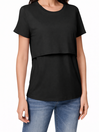 白背景のスタジオで撮影された、レイヤー構造のブラック授乳Tシャツをデニムと合わせた着用イメージ（上半身〜腰まで）。
