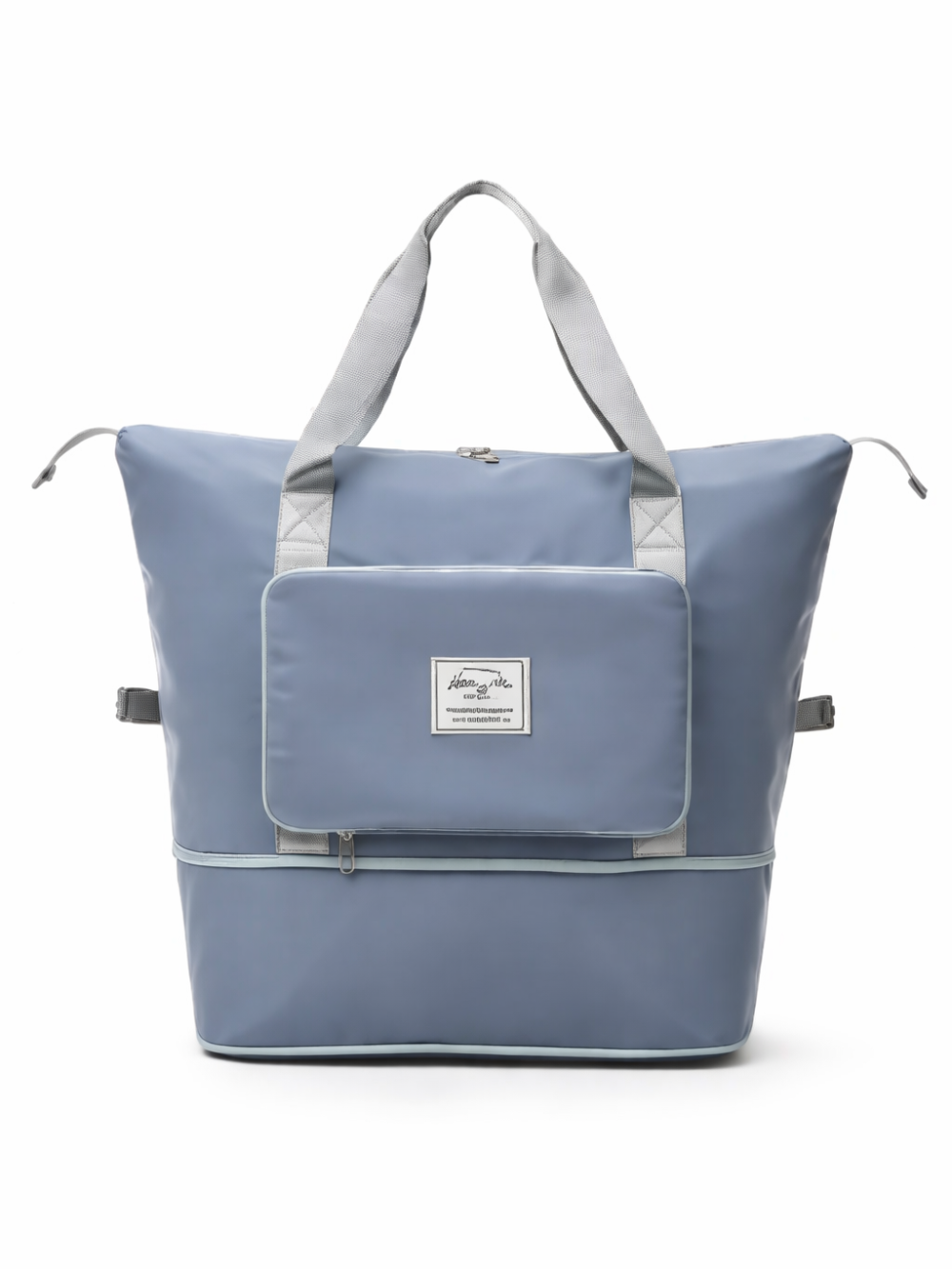 白背景のスタジオで撮影された、ライトブルーの大容量トートバッグ。グレーの持ち手と前面フラップポケット、ファスナー付きの下部収納、サイドベルトが付いている。
