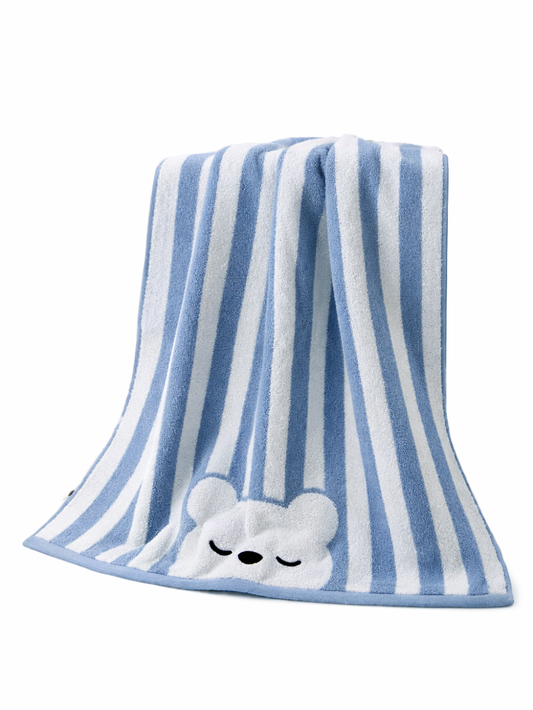 青と白のストライプ柄のベビー用タオルが白背景に掛けられており、下部に眠った表情のクマの刺繍モチーフが付いている。

