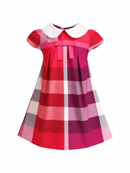 青・赤・ピンク系のチェック柄に白いピーターパンカラーと胸元リボンが付いた、半袖の子ども用Aラインワンピースを、白背景で正面から撮影した商品画像。
