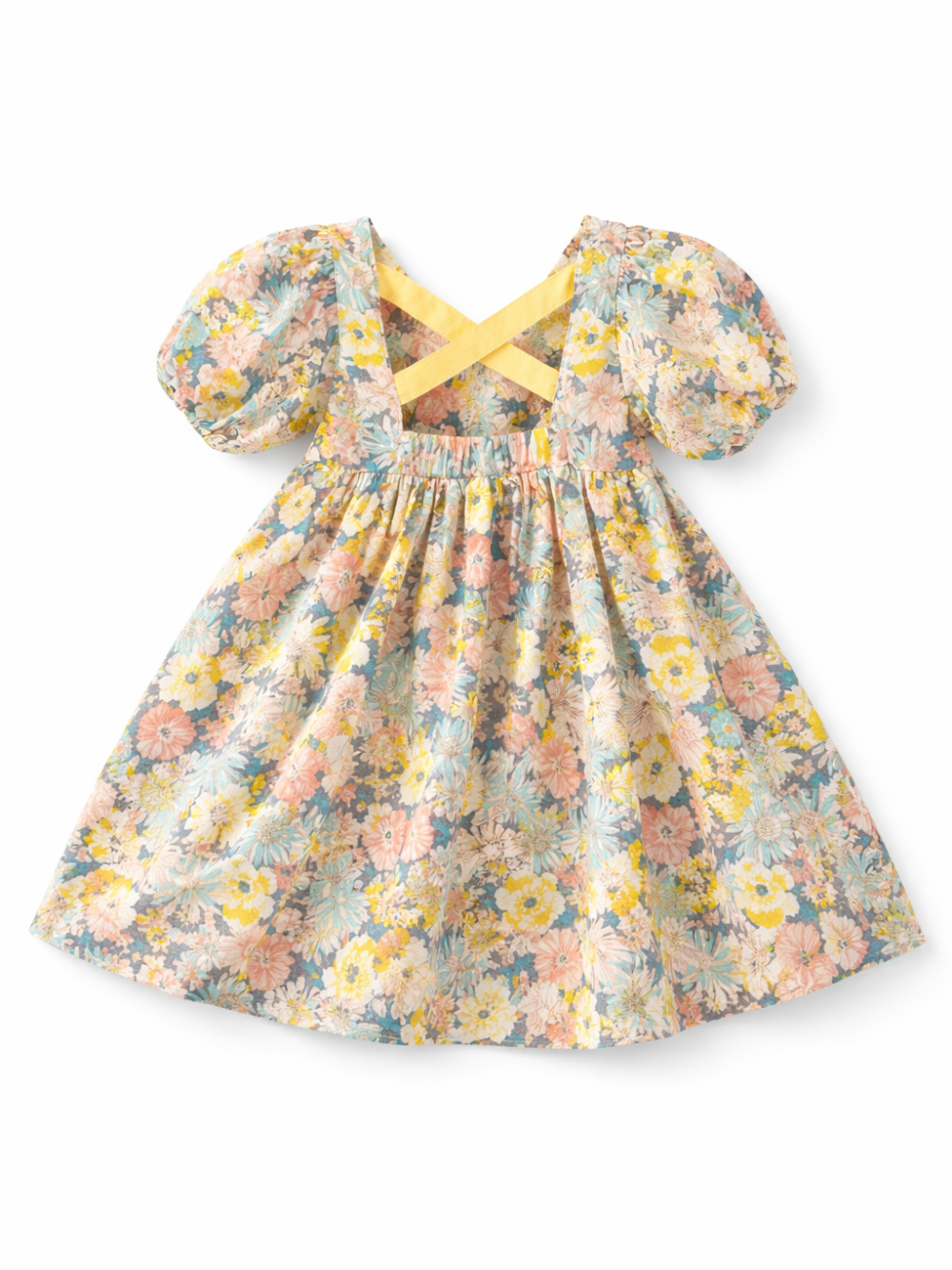 パステル調の花柄プリントが施された女の子用ワンピースの平置き写真。ふんわりしたパフスリーブ、背面のクロスストラップ、ギャザー入りウエストが特徴で、白背景に単体で配置されている。
