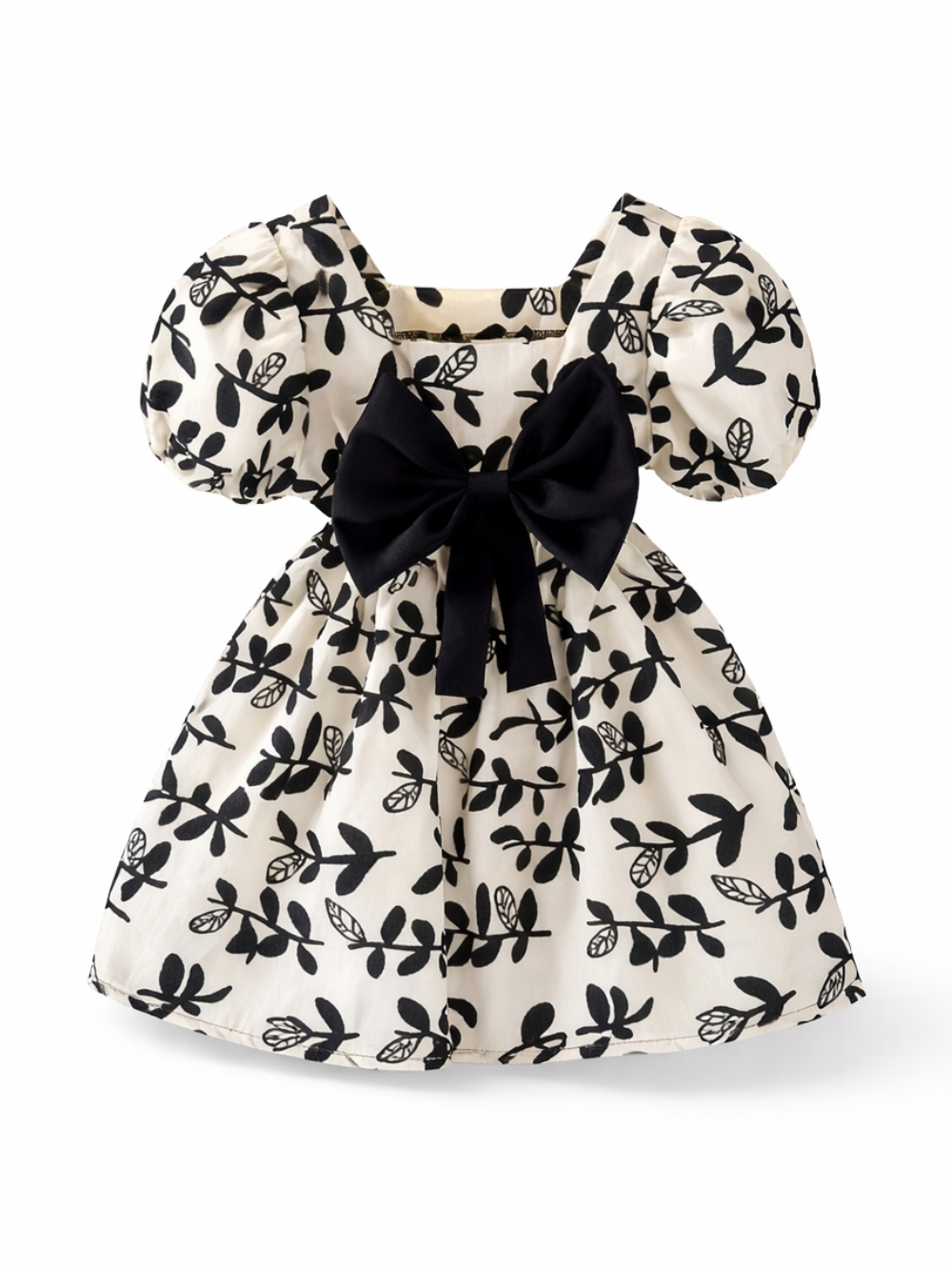 白地に黒のボタニカル柄が映える、パフスリーブとスクエアネックのキッズワンピース。ウエストの大きな黒リボンがアクセントで、白背景に正面から単体で撮影されている。
