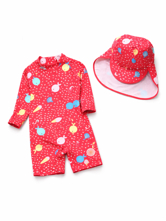 赤い子ども用ラッシュガード水着（長袖・ショート丈）と、同柄のつば広サンハットの2点セット。水着はカラフルな海のモチーフ柄（魚・貝・幾何学模様）プリント。白背景のスタジオ撮影で、商品を並べて配置している。