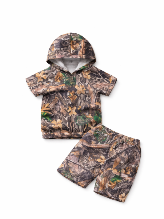 子ども用の迷彩柄ツーピース（フード付き半袖トップス＋ウエストゴムのショートパンツ）を白背景でフラットレイ撮影した商品画像。