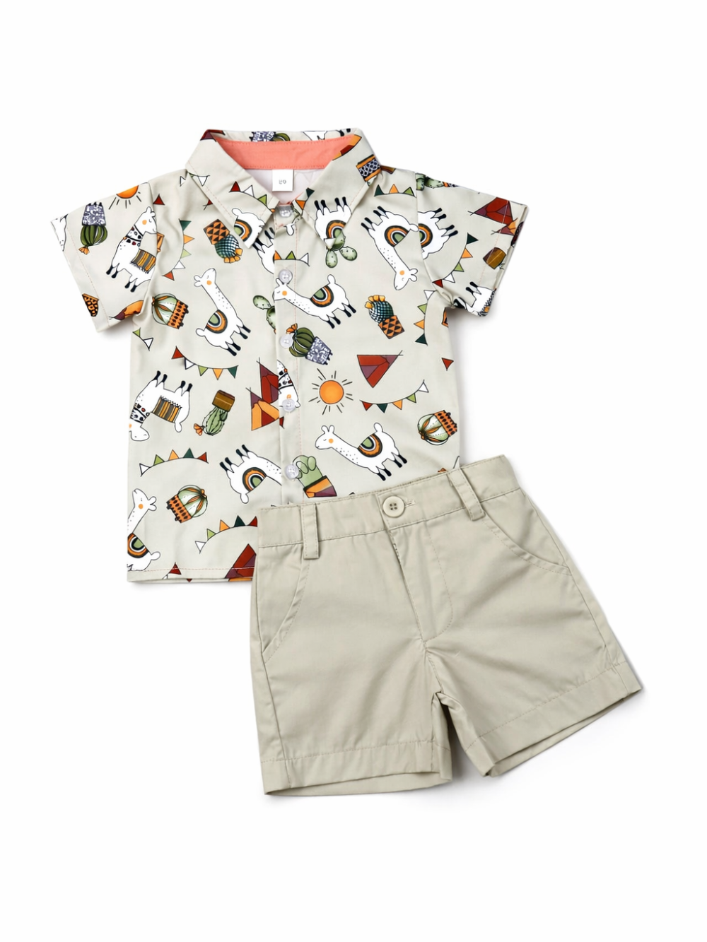 白背景のスタジオ撮影。ベージュの半袖シャツとベージュのショートパンツのキッズ上下セットで、シャツにはラマやサボテン、テントなどのキャンプ風イラストがプリントされ、パンツは前ボタンとサイドポケット付き。全体が高解像度でくっきり写っている。
``
