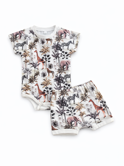 白地にサファリ柄（キリン・シマウマ・ゾウなど）をプリントしたベビー用半袖ロンパースとおそろいショーツの2点セット。
