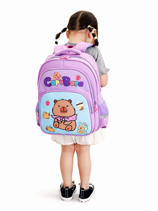 女の子が背負っている、パープル×水色のカピバラ柄キッズリュック。背面からの着用イメージを白背景で撮影。
