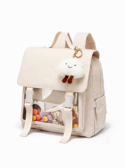 生成りカラーのキャンバス風リュック。フラップ留めベルトと透明フロントポケット、雲のぬいぐるみチャーム付きで、白背景に斜め前から撮影。