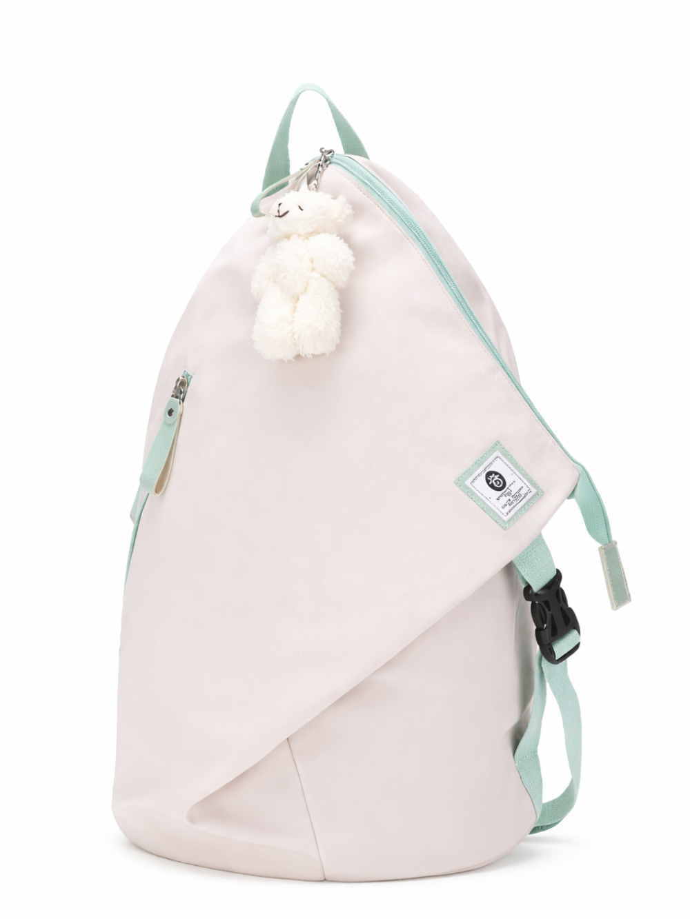 白背景に、アイボリーのワンショルダーバッグ（スリングバッグ）が斜め前向きに写っている。ミントグリーンの持ち手・ストラップ・ファスナーがアクセントで、ファスナー部分に白いぬいぐるみチャームが付いている。下に自然な薄い影が入っている。
