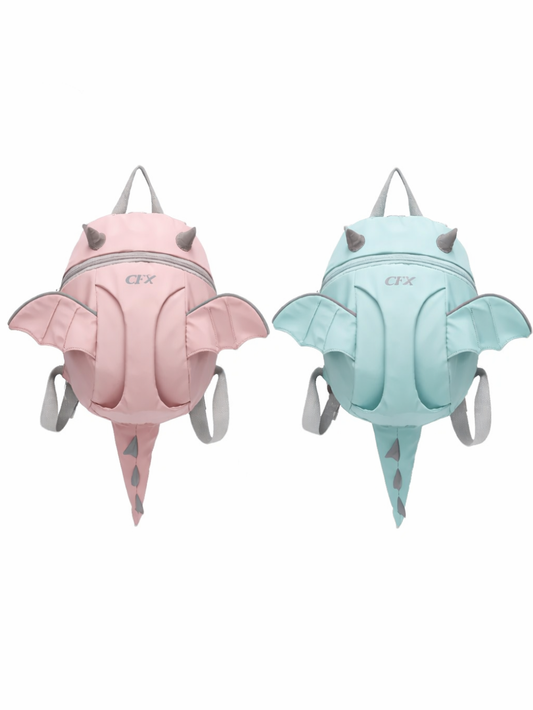 白背景に、ドラゴン（コウモリ風）の羽と小さな角、トゲ付きのしっぽが付いた子ども用リュックが2点、正面向きで並んでいる。左は淡いピンク、右は淡いミントブルーで、いずれもグレーの持ち手とショルダーストラップ付き。下に自然な薄い影が入っている。
