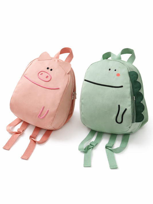 白背景に、動物モチーフの子ども用リュックが2点並んでいる。左は淡いピンクのブタデザインで、耳と鼻の刺繍がある。右は淡いグリーンの恐竜デザインで、側面にトゲの装飾が付いている。どちらもストラップが見え、下に自然な薄い影が入っている。
