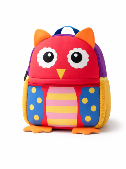 白背景に、フクロウモチーフの子ども用リュックが正面から写っている。赤い本体に大きな白い目、オレンジの耳と足、青い前面ポケットと黄色の水玉があり、中央にピンク×黄色のストライプ模様が入っている。両側にメッシュポケットがあり、下に自然な薄い影が入っている。
