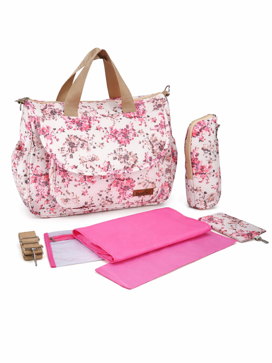 白い背景のスタジオ撮影で、ピンクの花柄が入ったマザーズバッグ（ダイパーバッグ）と、同柄のボトルポーチ・小物ポーチ、ピンクの折りたたみおむつ替えマット、ストラップ金具が並べて映っている商品画像。
