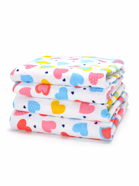 白地にカラフルなハート柄がプリントされた布おむつ（フラットタイプ）が4枚きれいに重ねて折りたたまれ、白い背景の上に置かれている。