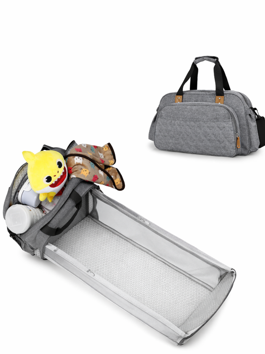 白い背景の上に、グレーのマザーズバッグと、バッグから展開できるメッシュ付きのポータブルベビーベッドが写っている。ベビーベッドは空の状態で、横に開いたバッグ部分におもちゃとブランケットが入っており、上部には同色のバッグが別角度で置かれている。
