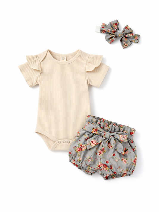 ベージュのリブ素材フリル袖ロンパース、グレーの花柄ブルマ（リボン付き）、おそろいの花柄ヘアバンドを白背景に並べたベビー用3点セットの写真。