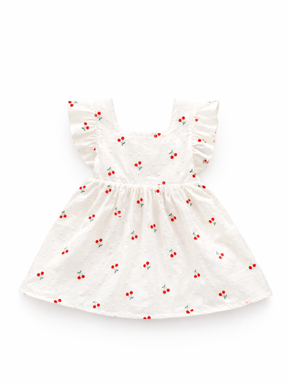 白背景のスタジオ撮影。小さなチェリー柄とドット状の立体織りが入った白いベビー用ワンピースで、スクエアネックとフリル袖、ギャザーのスカートが平置きで写っている。
