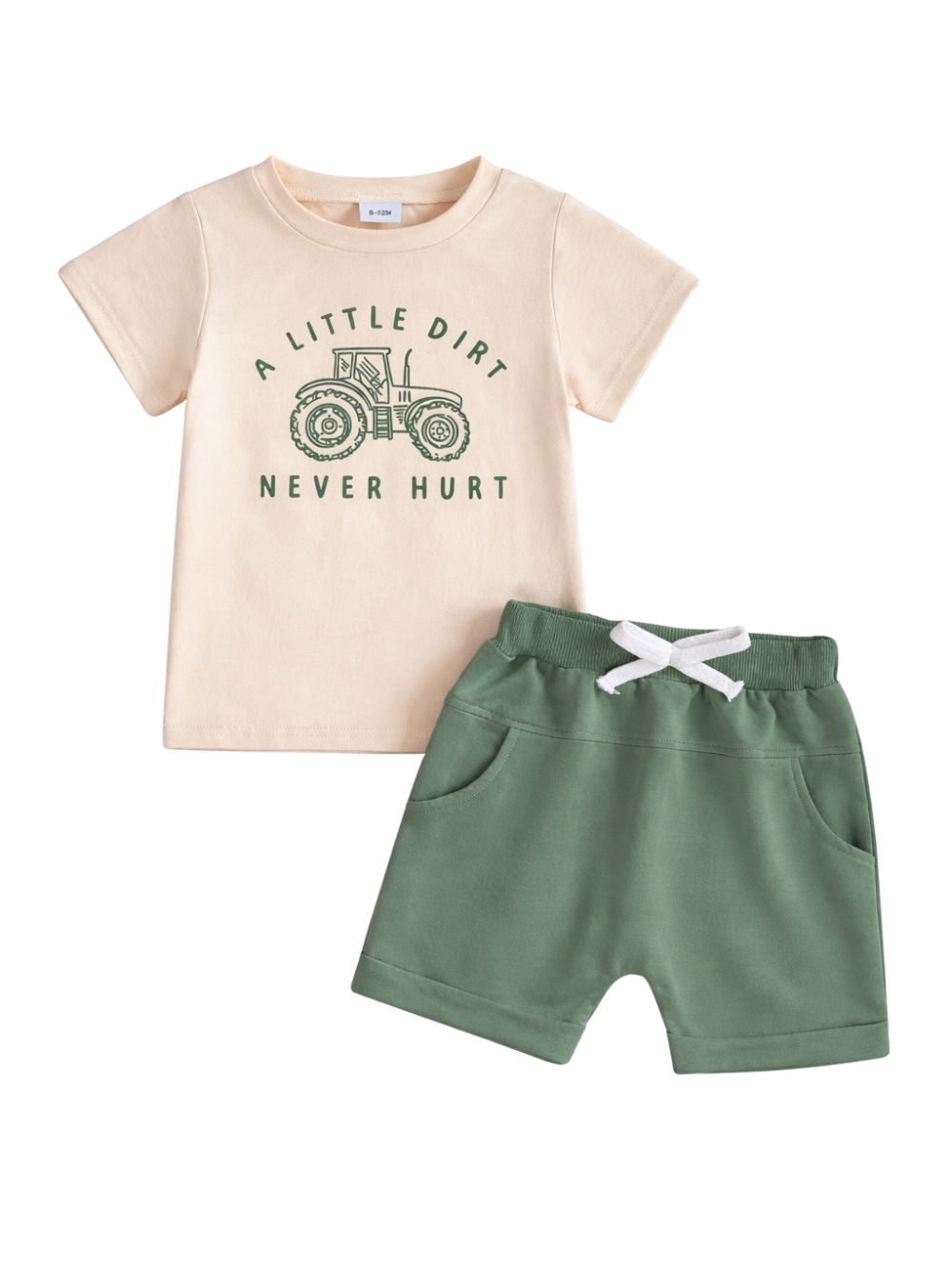 白背景のスタジオ撮影。ベージュの半袖Tシャツ（トラクターのイラストと英字プリント）と、白いひも付きのグリーンのショートパンツが上下セットで並んで写っている。
