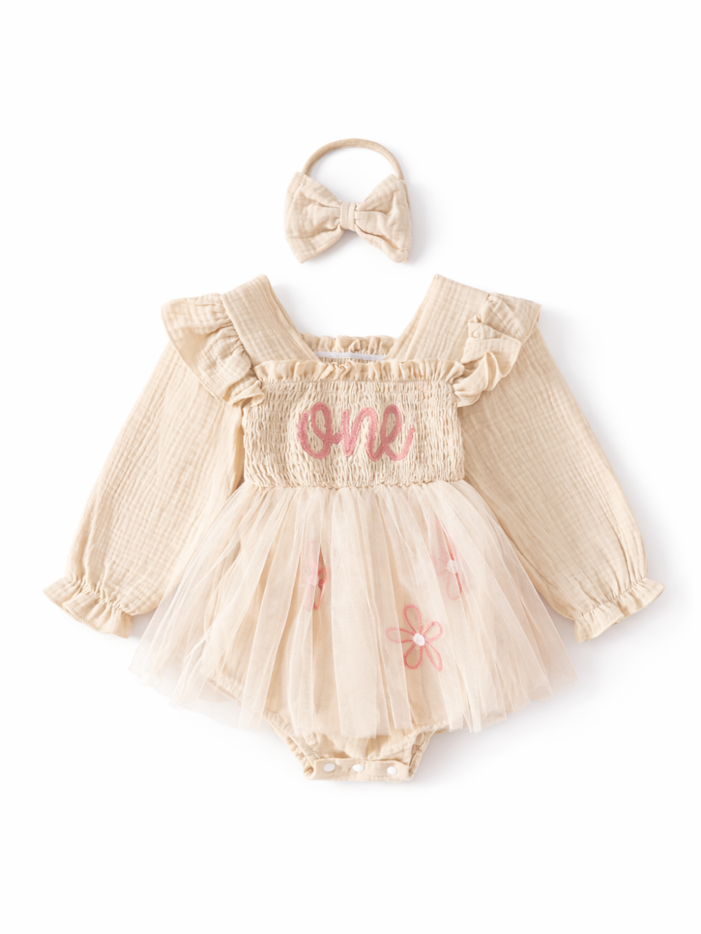 白背景に、ベージュのベビーロンパース（長袖）とチュールスカートのセット。胸元にピンクの刺繍「one」と花の刺繍があり、上部に同色のリボンヘアバンドが置かれている。
