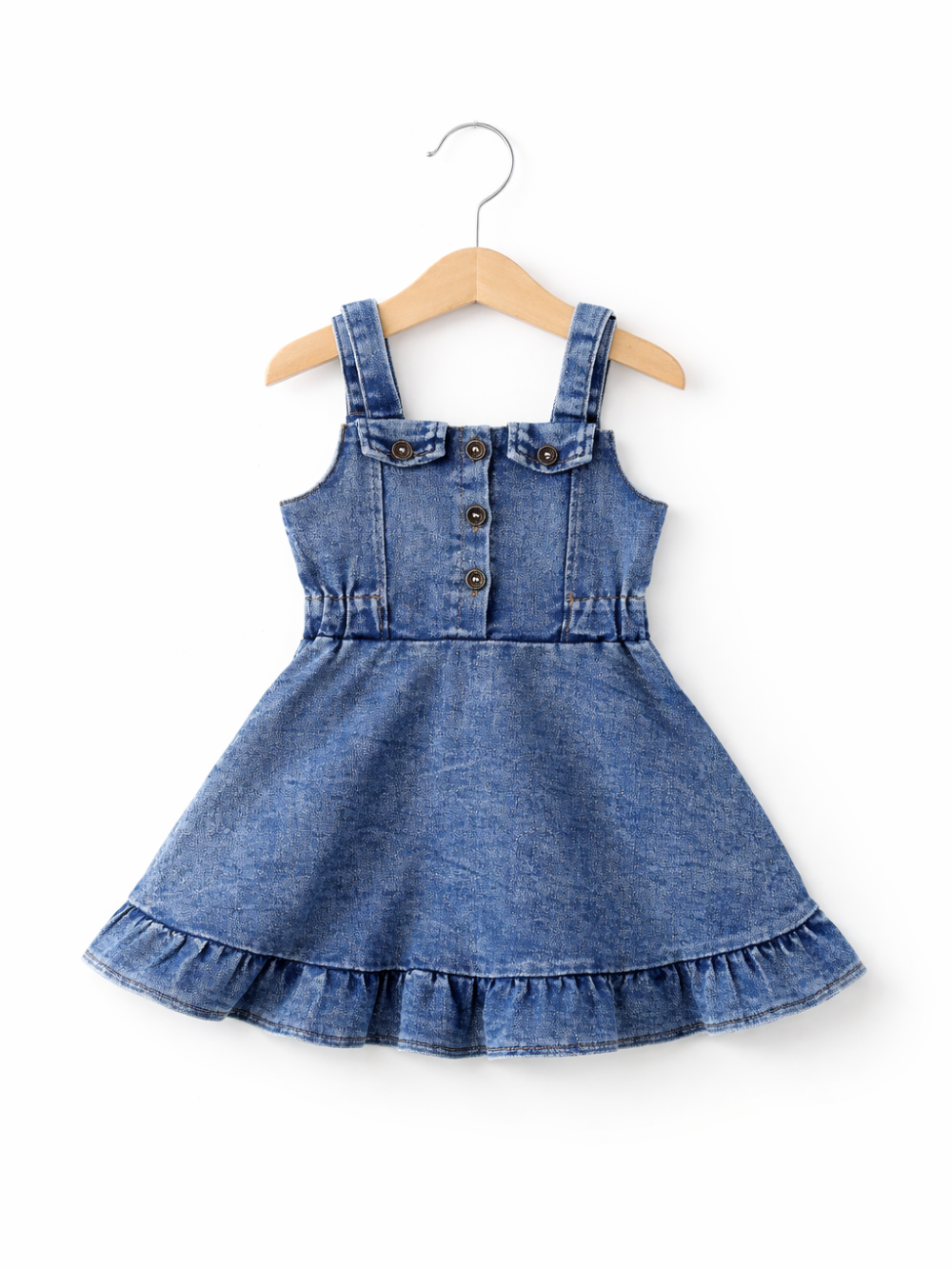 デニム素材の女の子用ジャンパースカートが木製ハンガーに掛けられ、白背景に正面から撮影されている。フロントボタン付きの胸当てと肩ひも、裾のフリルが特徴。