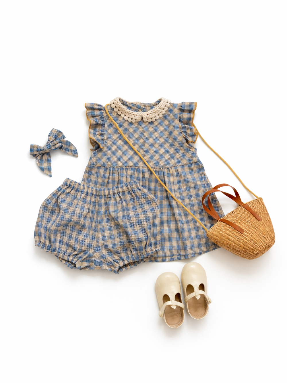 青とベージュのギンガムチェック柄のノースリーブトップス（かぎ針編み風の襟付き）とおそろいのブルマ、同柄のリボン、クリーム色のストラップシューズ、かごショルダーバッグを白背景に並べたベビー／キッズ用コーデセット。
