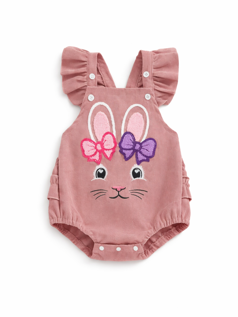 白背景に配置されたベビーロンパース。くすみピンクのコーデュロイ風生地で、フリル付きショルダーストラップとボタン留めデザイン。前面にウサギの顔と耳、ピンクと紫のリボン刺繍が入っている。
