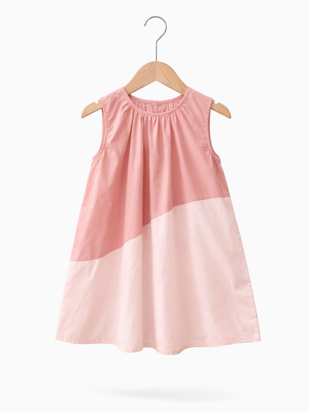 淡いピンクの配色切り替えが入ったノースリーブの子ども用ワンピースが、木製ハンガーに掛けられ、白い背景に単体で写っている。
