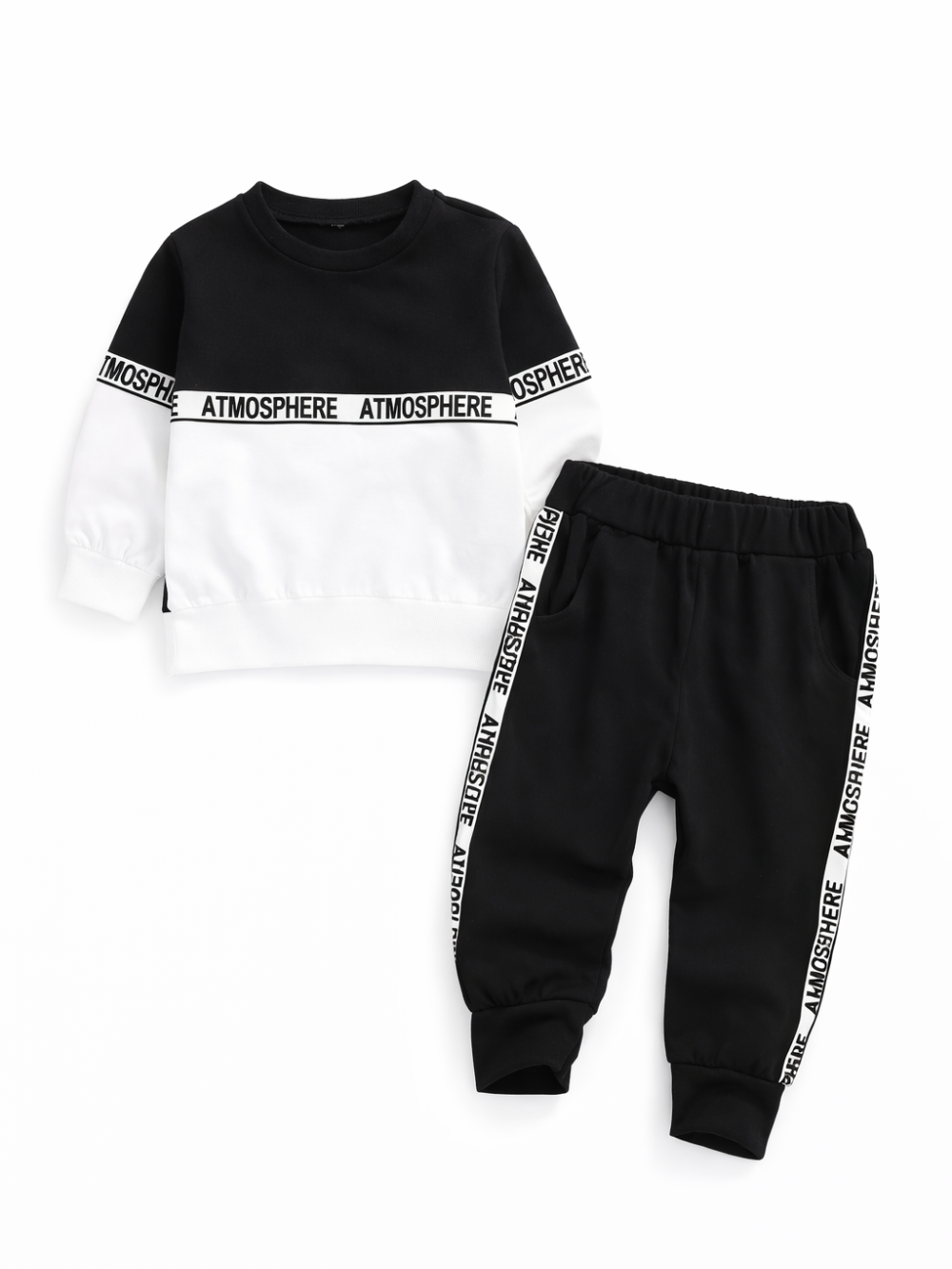 白い背景に、子ども用の上下セットがフラットレイで配置されている。ブラック×ホワイトの切り替えスウェットとブラックのジョガーパンツの組み合わせで、胸元と袖、パンツのサイドに「ATMOSPHERE」のロゴテープが入っている。
