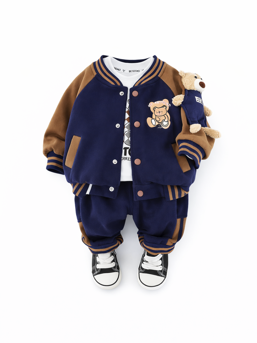 白い背景に、ネイビー×ブラウンのスタジャン風ジャケットとおそろいのパンツを合わせた幼児用セットアップが配置されている。胸元にクマの刺繍ワッペンがあり、袖にはぬいぐるみのクマが付いている。足元にはブラックのスニーカーが写っている。
