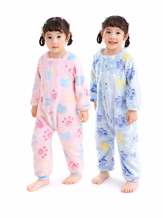 白背景のスタジオ風に、ふわふわ素材のキッズ用つなぎパジャマを着た女の子2人が並んで立っている。左はピンクのハートと肉球柄、右はブルーの肉球とハート柄で、どちらも前開きファスナー仕様。
