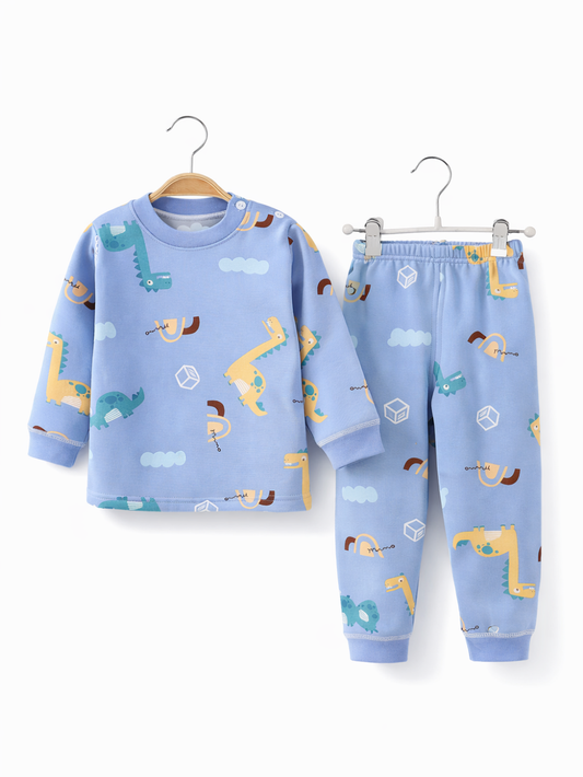 水色のキッズ用ルームウェア上下セット。恐竜と雲の総柄プリントの長袖トップスとロングパンツが、それぞれハンガーに掛けられた白背景のスタジオ撮影で、周囲の小物や手は写っていない。
