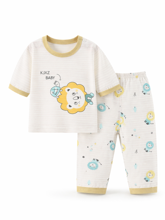 白背景のスタジオ風に、ベビー用上下セットが並べて撮影されている。アイボリーの半袖トップスはライオンのイラストプリントとベージュの縁取り付きで、右側に同柄プリント入りのアイボリーロングパンツがセットになっている。
