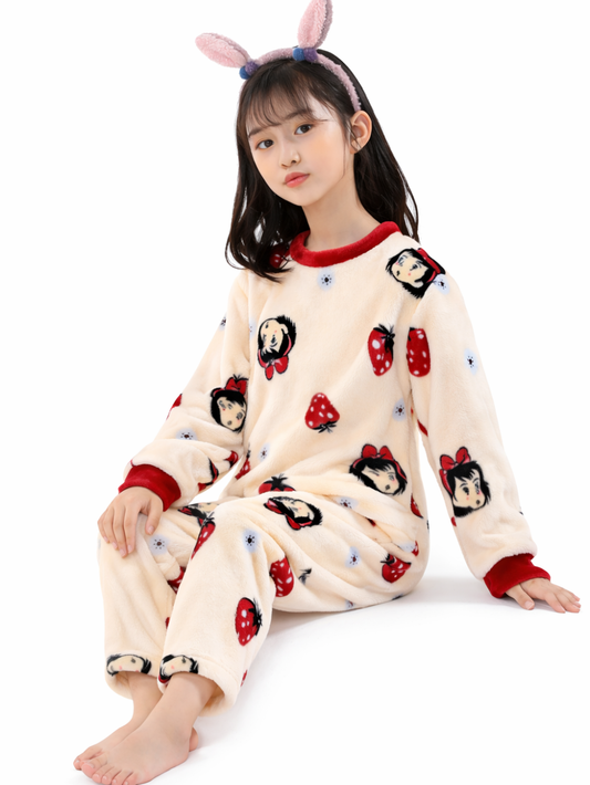 白背景のスタジオで、うさ耳カチューシャを付けた女の子が、赤い縁取りのあるクリーム色のフリースパジャマ（キャラクターといちご柄）を着て、足を伸ばして上品に座っている。
