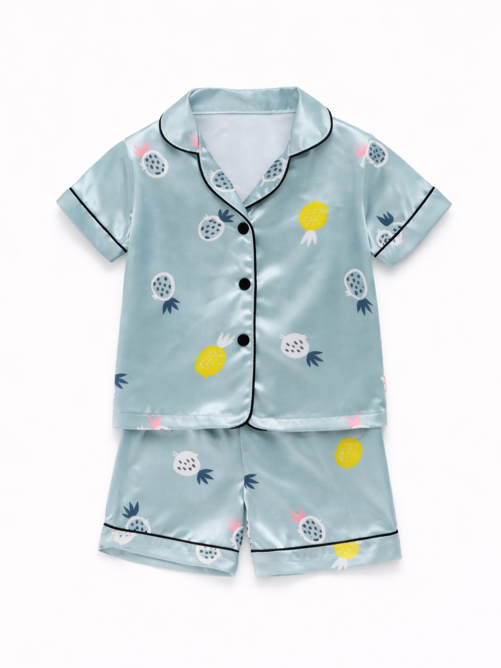 水色のサテン素材の子ども用半袖パジャマ上下セット。パイナップル柄のトップス（黒ボタン・黒パイピング）と同柄ショーツを白背景にフラットレイで配置した商品画像。
