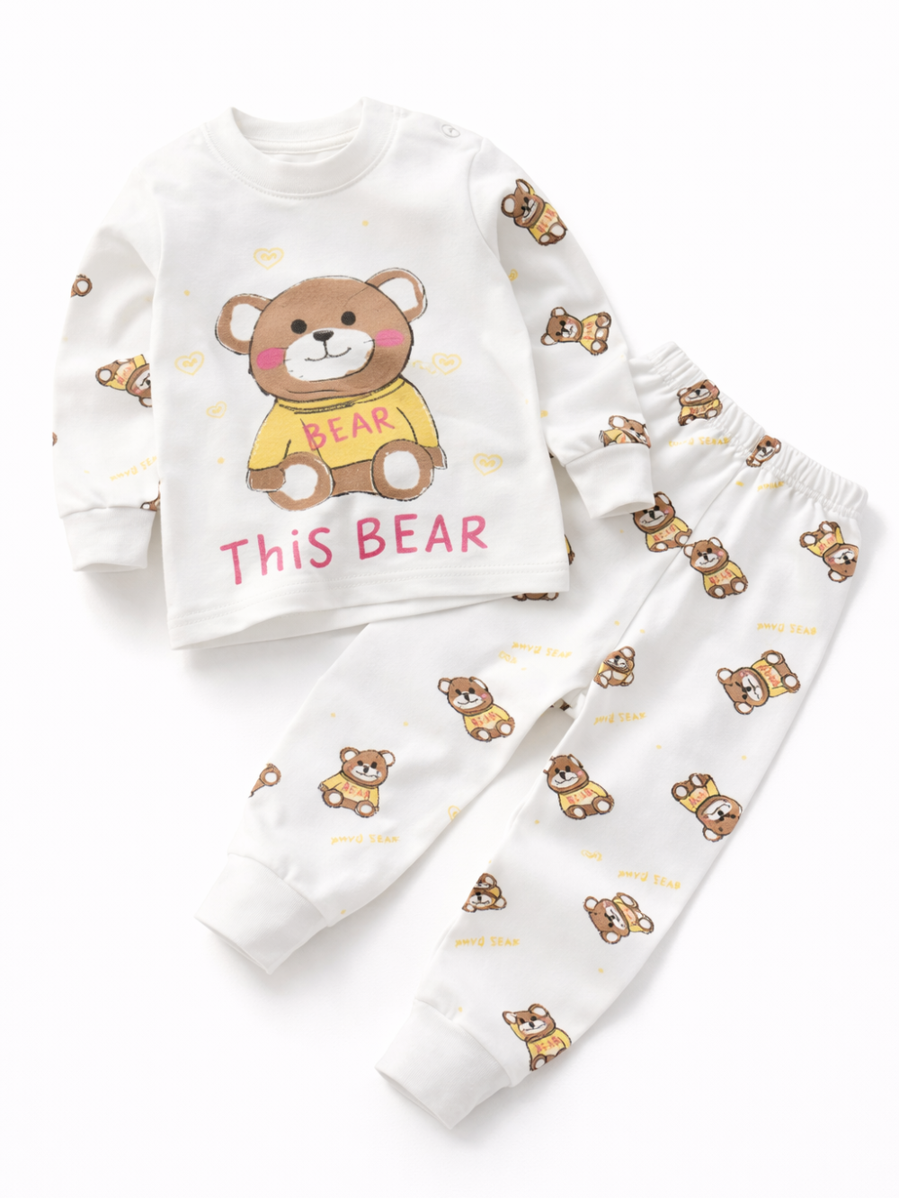 白背景に置かれた子ども用の上下パジャマセット。白い長袖トップスに黄色い服を着たクマのプリント、パンツにはクマ柄が全体に散りばめられている。
