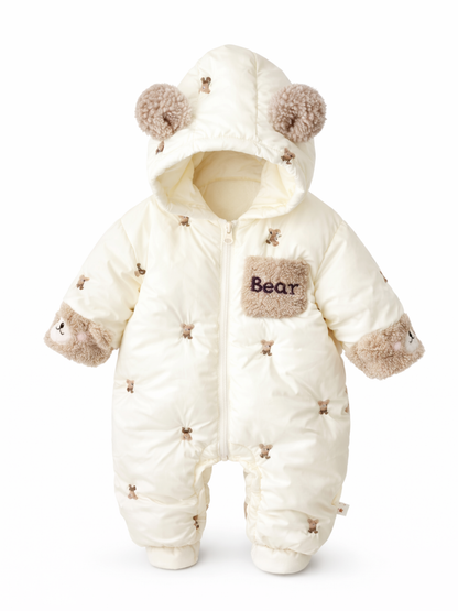 クリーム色のベビー用中綿ロンパース（クマ刺繍・耳付きフード・「Bear」ポケット・手首にクマモチーフ）を、白背景で正面から単体撮影した商品画像。
