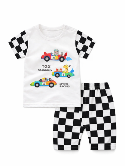 白背景に、子ども用の上下2点セットが平置きで配置されている。上は白い半袖Tシャツで、袖は黒×白のチェッカーフラッグ柄。胸元には動物が乗ったカラフルなレーシングカーのイラストと「TGX GRANDPRIX」「SPEED RACING」の文字がプリントされている。下は黒×白のチェッカーフラッグ柄のショートパンツで、ウエストはゴム仕様。全体が均一な光で撮影され、輪郭がはっきり見える。```
