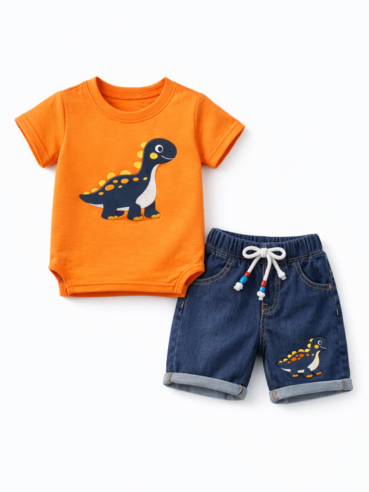 白背景のスタジオ撮影で、子ども用2点セットをフラットレイで配置。恐竜プリントのオレンジ半袖Tシャツと、裾を折り返したデニムショートパンツ（ウエスト紐・恐竜ワッペン付き）を組み合わせたデザイン。
