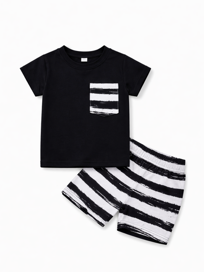白い背景に、子ども用の上下セットが配置されている。黒の半袖Tシャツには白黒ストライプ柄のポケットが付き、同じストライプ柄のショートパンツが斜めに重なるように並んでいる。
