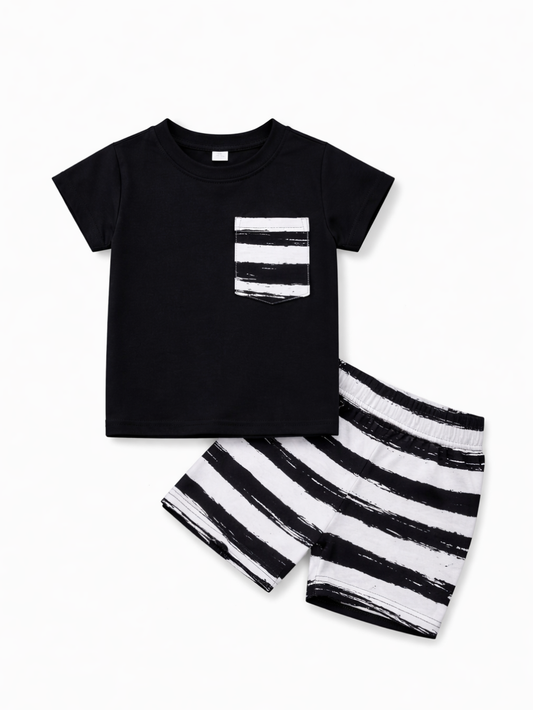 白い背景に、子ども用の上下セットが配置されている。黒の半袖Tシャツには白黒ストライプ柄のポケットが付き、同じストライプ柄のショートパンツが斜めに重なるように並んでいる。
