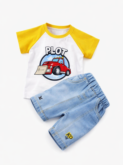 白背景に、子ども用の上下セットがフラットに配置された商品写真。黄色のラグラン袖と首まわりの白いTシャツに、赤いはたらく車のイラストと「PLOT」の文字。下には薄いブルーのデニム風ショートパンツが斜めに重ねて置かれ、裾に小さなロゴ刺繍が見える。
