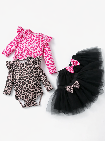白背景に、ベビー用の長袖ロンパース2枚（ピンクのレオパード柄とグレーのレオパード柄）と、リボン付きの黒いチュチュスカートが並べて置かれているフラットレイ写真。
