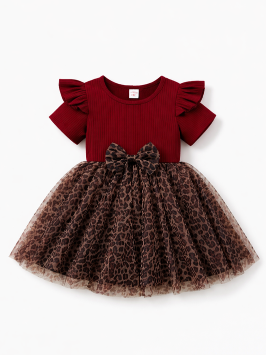 白背景に、ボルドーのリブトップ（フリル袖）とヒョウ柄チュールスカートが一体になった女の子用ワンピース（ウエストリボン付き）のフラットレイ。
