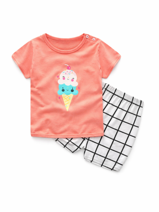 白背景に平置きされた、コーラルピンクのアイスクリーム柄半袖Tシャツと白×黒格子柄ショートパンツの2点セット。
