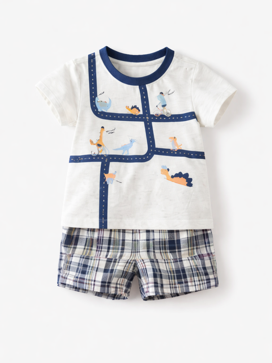 白地にネイビーの襟・パイピングが入った恐竜柄の半袖Tシャツと、ネイビー系チェック柄ショートパンツの2点セットを、白い背景にフラットレイで並べた商品写真。
