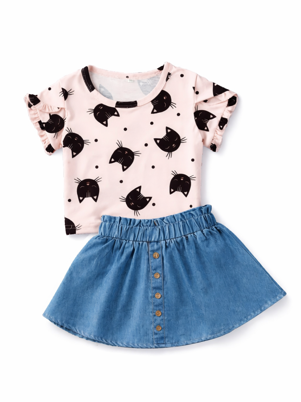白背景に平置きされた女の子用2点セット。黒い猫フェイス柄の淡いピンクのフリル袖トップスと、フロントボタン付きのブルーデニムスカート。
