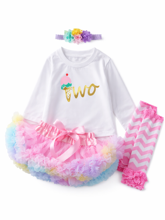 白い長袖トップス（アイスクリーム柄「two」ロゴ）、カラフルなチュチュスカート、ピンクのジグザグ柄レギンス、花付きヘアバンドのベビー女の子用4点セット（スタジオ白背景）
