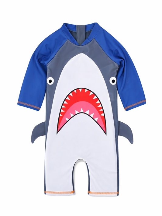白背景に、サメ柄の子ども用ワンピース水着（ラッシュガード）が正面から写っている。ブルーの長袖とグレー×白のボディに、赤い口と白い歯のデザイン、両脇には小さなヒレが付いている。
