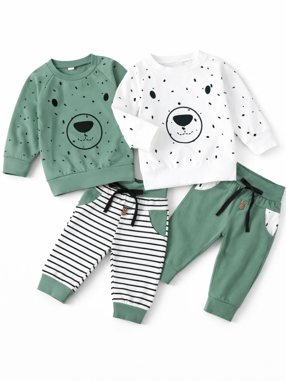 白背景に並べたキッズ用スウェット上下セット2種類。左はグリーンのくま顔プリントトレーナー＋白黒ボーダーのパンツ、右は白地ドット柄のくま顔プリントトレーナー＋グリーンのパンツで、いずれもリブ袖・裾とウエスト紐付き。
