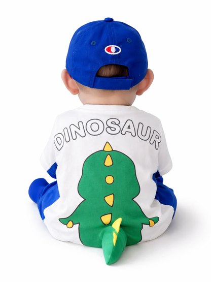 白背景で後ろ向きに座る赤ちゃん。青いキャップをかぶり、背中に「DINOSAUR」の文字と大きな緑の恐竜イラスト（立体しっぽ付き）が入った白×青のベビー服を着ている。

